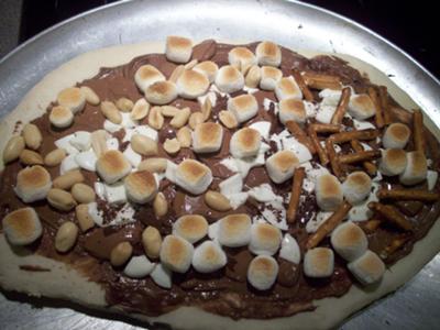 Chocolate Pizza with Nutella, dark, milk and white chocolates, toasted marshmallows, pretzels and peanuts. Yum!