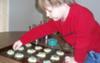 my son decorating the cookies with sprinkles